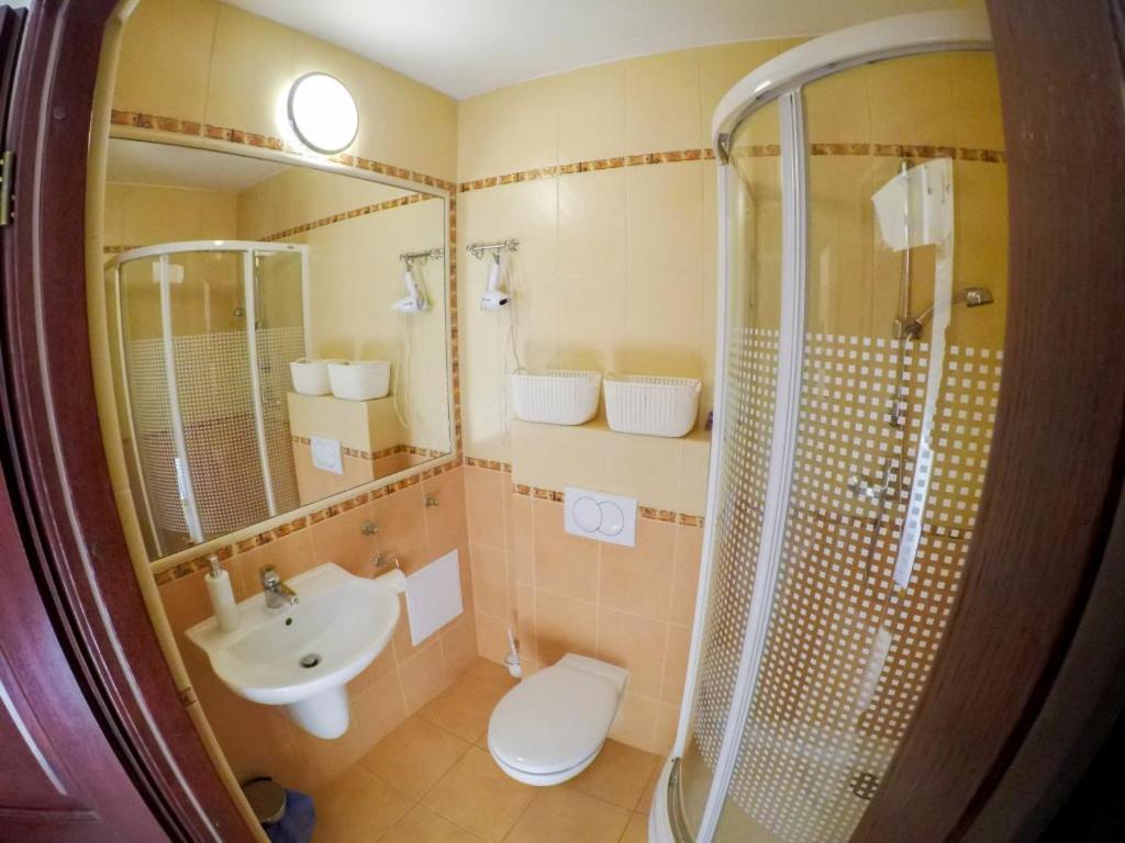 a bathroom with a sink and a toilet and a shower at Apartament 506 Krynica Zdrój Centrum in Krynica Zdrój