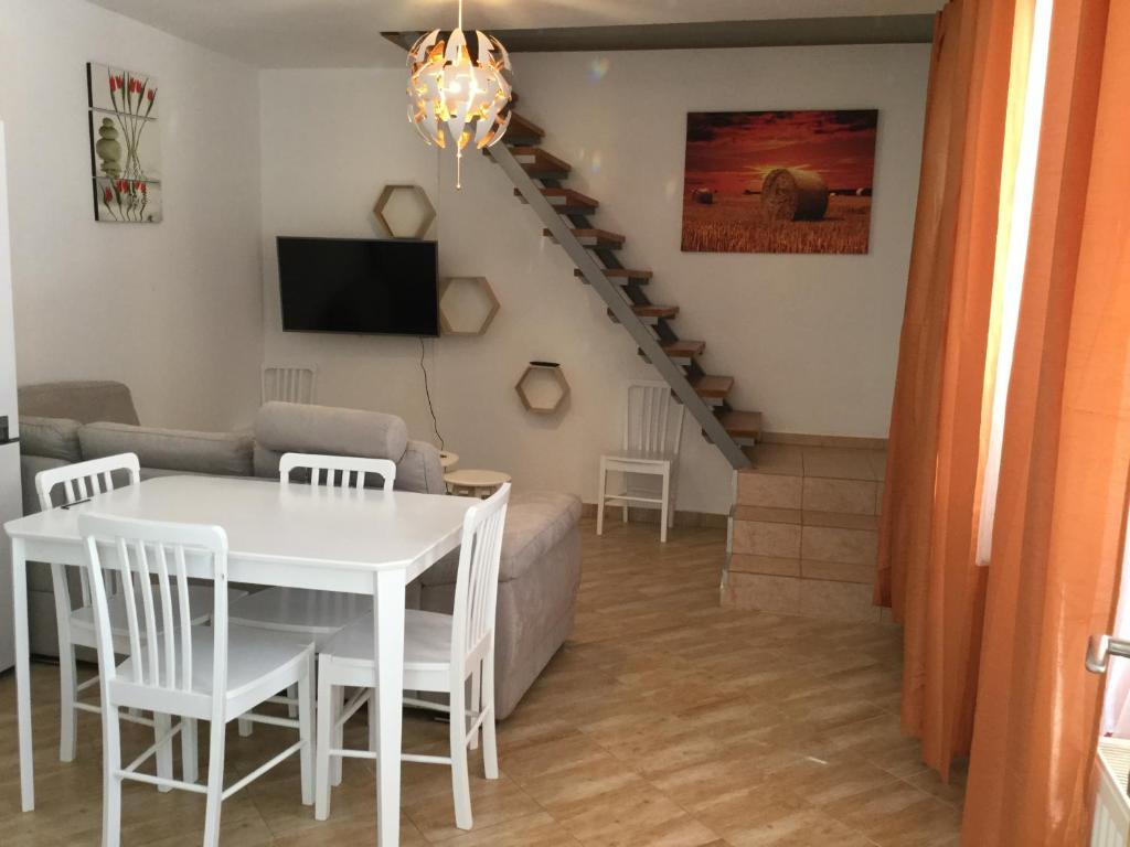 uma sala de estar com uma mesa e cadeiras brancas e uma escadaria em JUDIA em Litomyšl