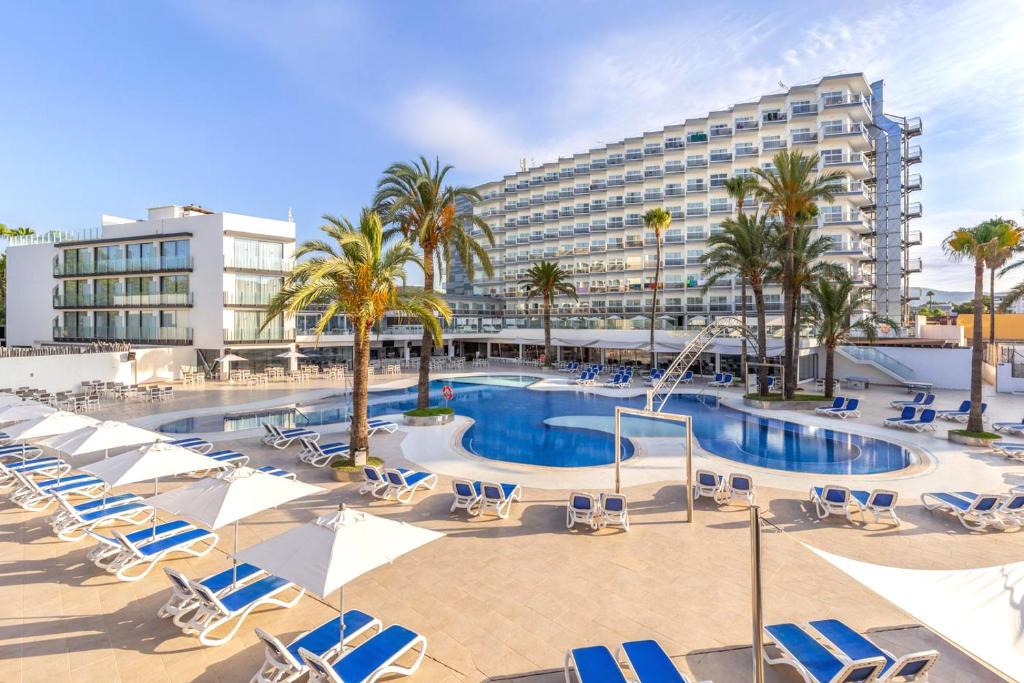 a swimming pool with lounge chairs and a hotel at Hotel Samos in Magaluf