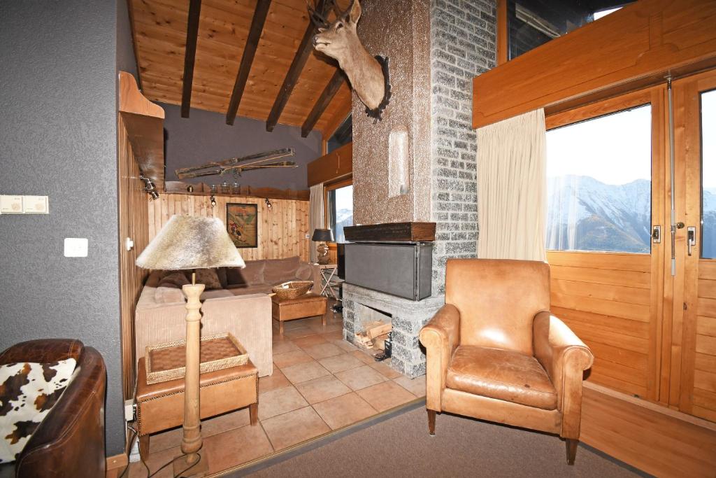 a living room with a chair and a fireplace at Rübezahl | Dachgeschoss in Riederalp