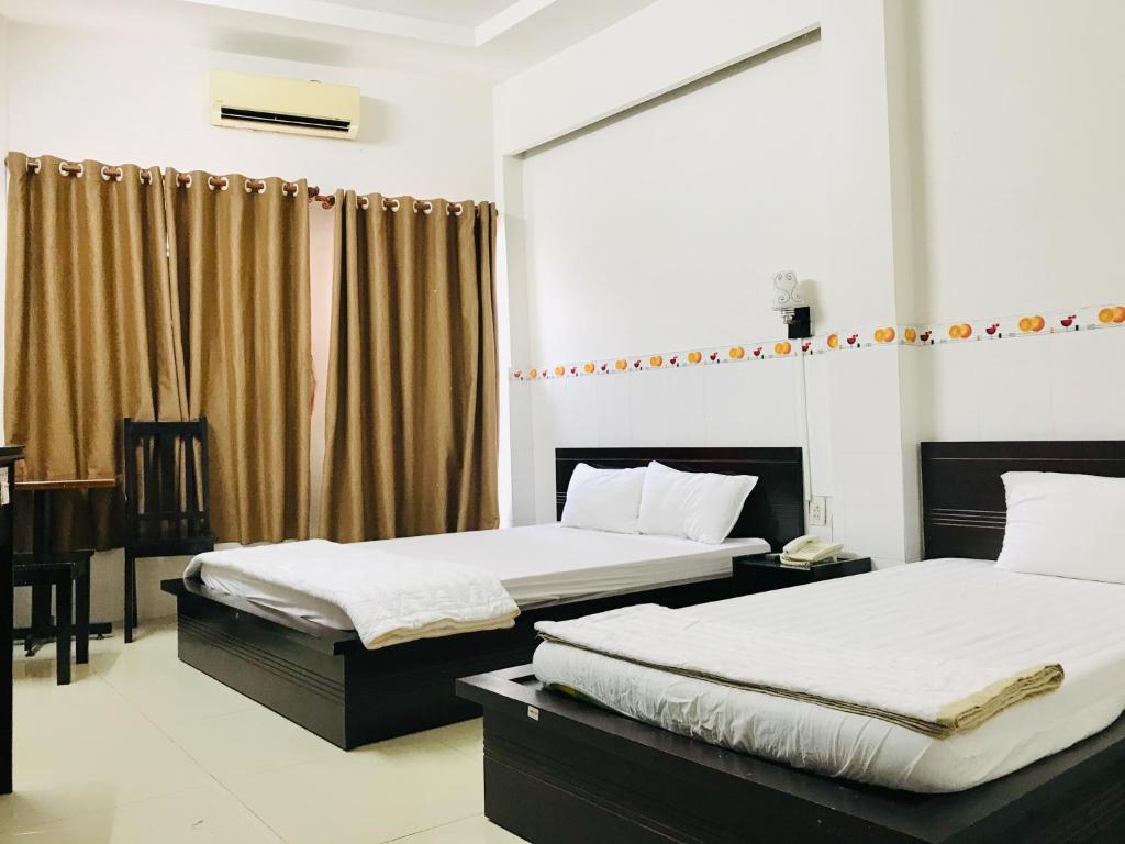 1 dormitorio con 2 camas y escritorio. en OYO 1148 Thien Huong Hotel, en Can Tho