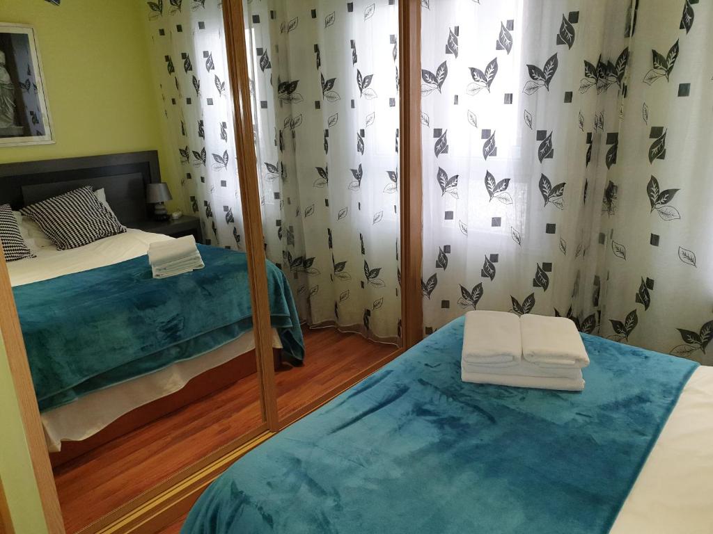 1 dormitorio con 2 camas y espejo en Centroapartament Las Letras, en Madrid