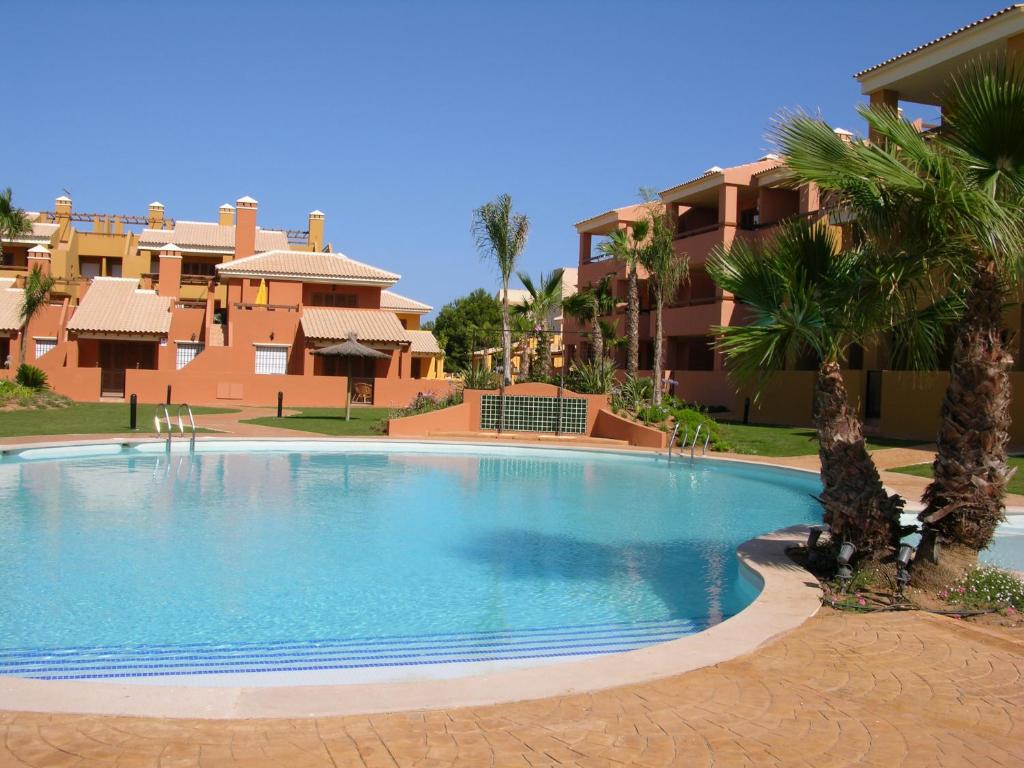 uma grande piscina com palmeiras em frente a um edifício em Albatros Playa 3 - 4908 em Mar de Cristal