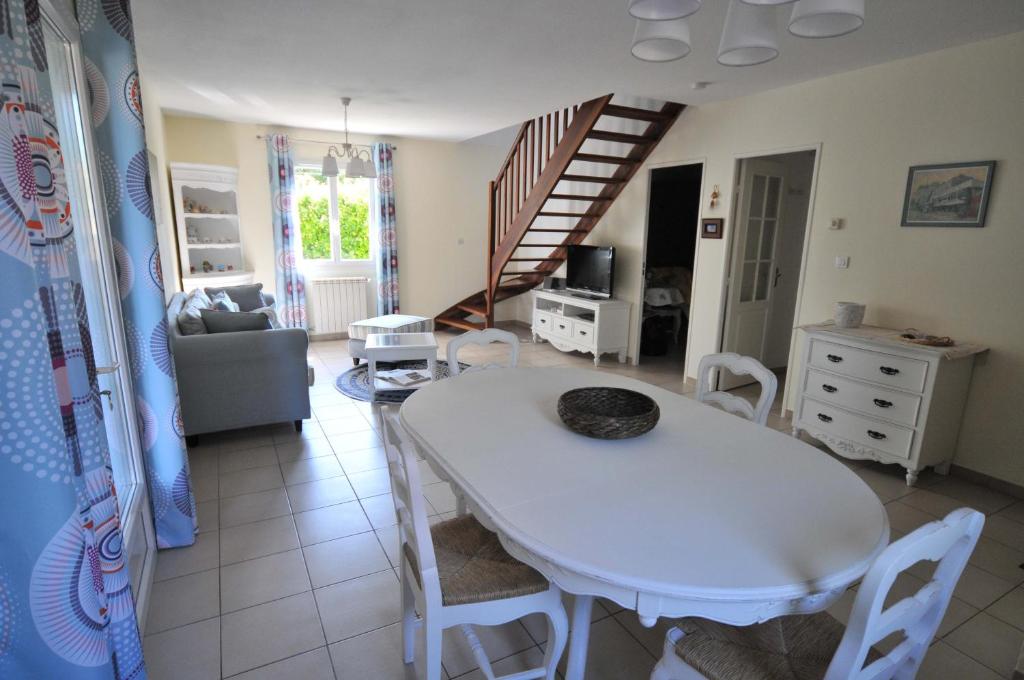 sala de estar con mesa blanca y sillas en Gîte de Catherine en Saint-Didier