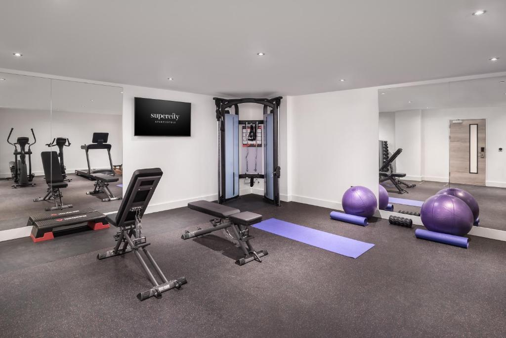a gym with several exercise equipment in a room at Q Square by Supercity Aparthotels in Brighton & Hove
