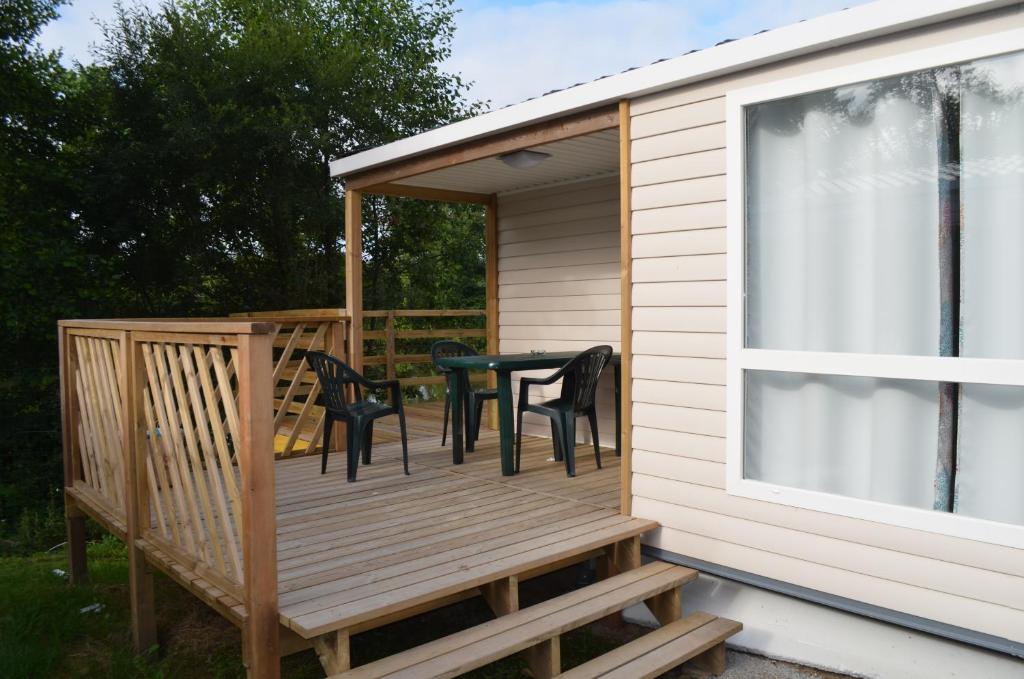 a deck with a table and chairs on it at Camping La Venise Du Bocage in Nesmy