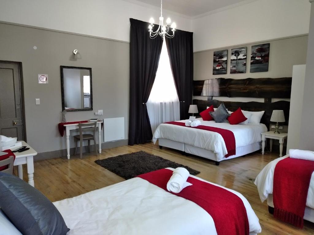 a hotel room with two beds and a mirror at Deo Resta Guest Lodge in Piet Retief