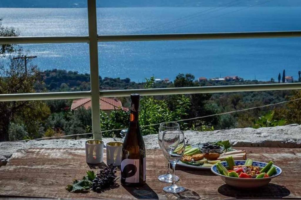 a table with a bottle of wine and a bowl of food at Arsinoe - Cosy guesthouse- in Methana