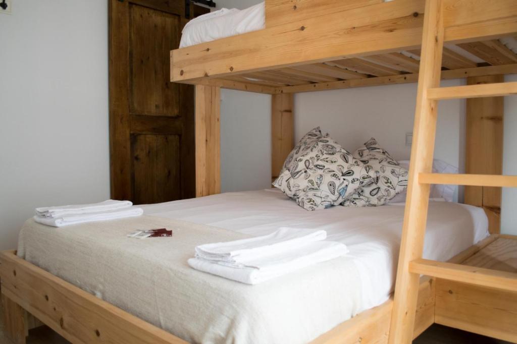 ein Etagenbett mit weißen Handtüchern darüber in der Unterkunft Latas Surf Lodge in Loredo