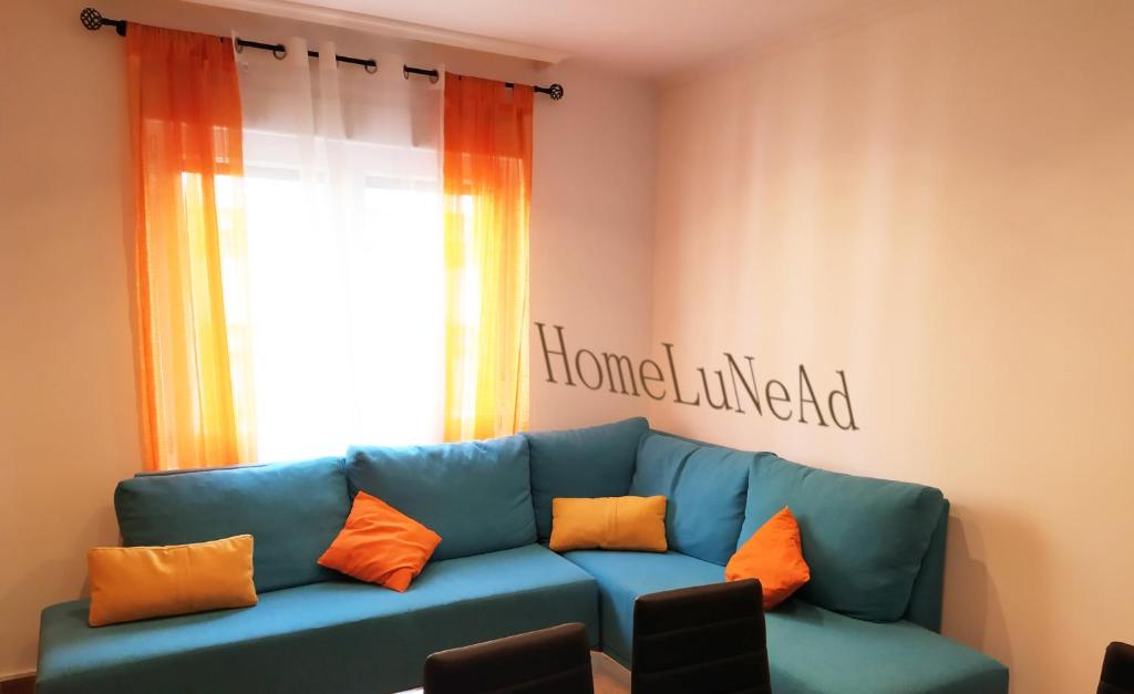 sala de estar con sofá azul y almohadas de color naranja en Homelunead Apartamento en Gijon Centro al lado de la Playa, en Gijón