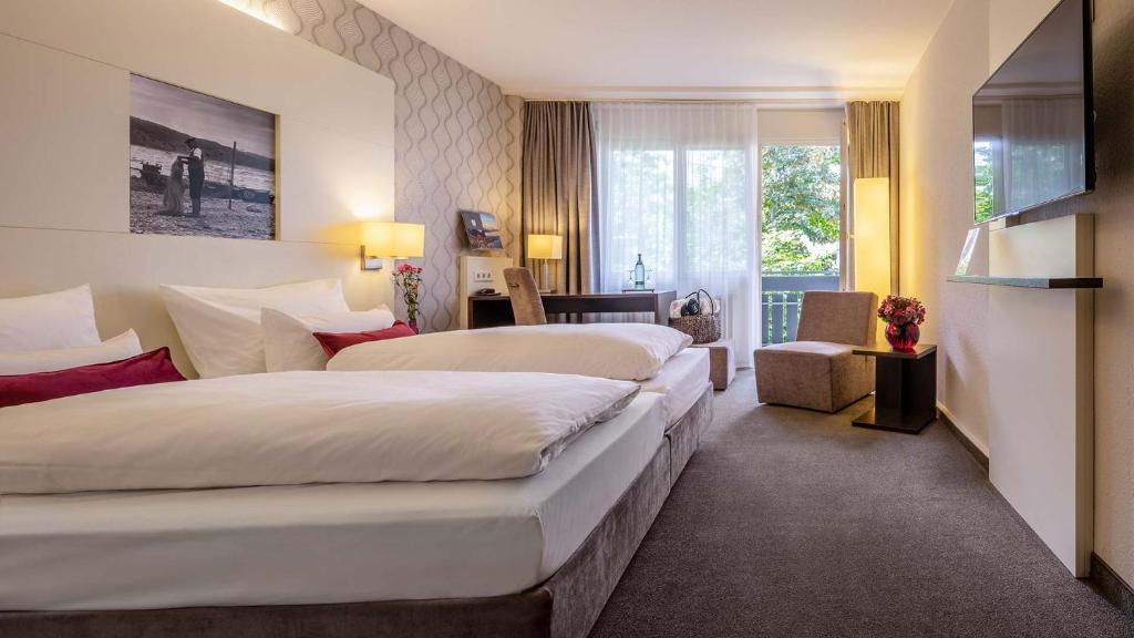 ein Hotelzimmer mit 2 Betten und einem Fenster in der Unterkunft Ganter Hotel & Restaurant Mohren in Reichenau