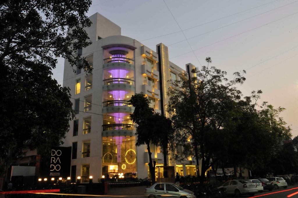 un edificio con luces púrpuras en el lateral. en Hotel El Dorado, en Ahmedabad