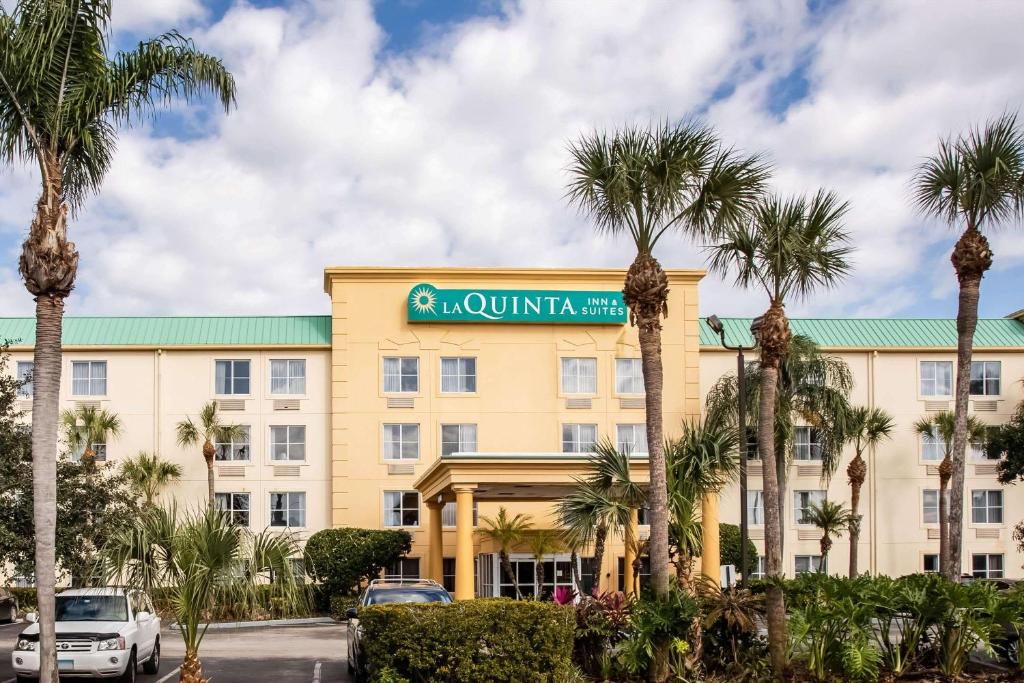 a hotel with palm trees in front of it at La Quinta by Wyndham Melbourne Viera in Melbourne