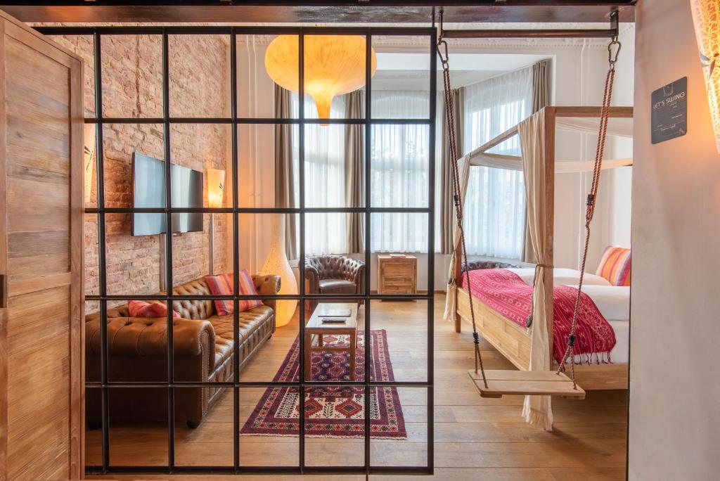 una habitación con un columpio y un dormitorio en Lulu Guldsmeden en Berlín