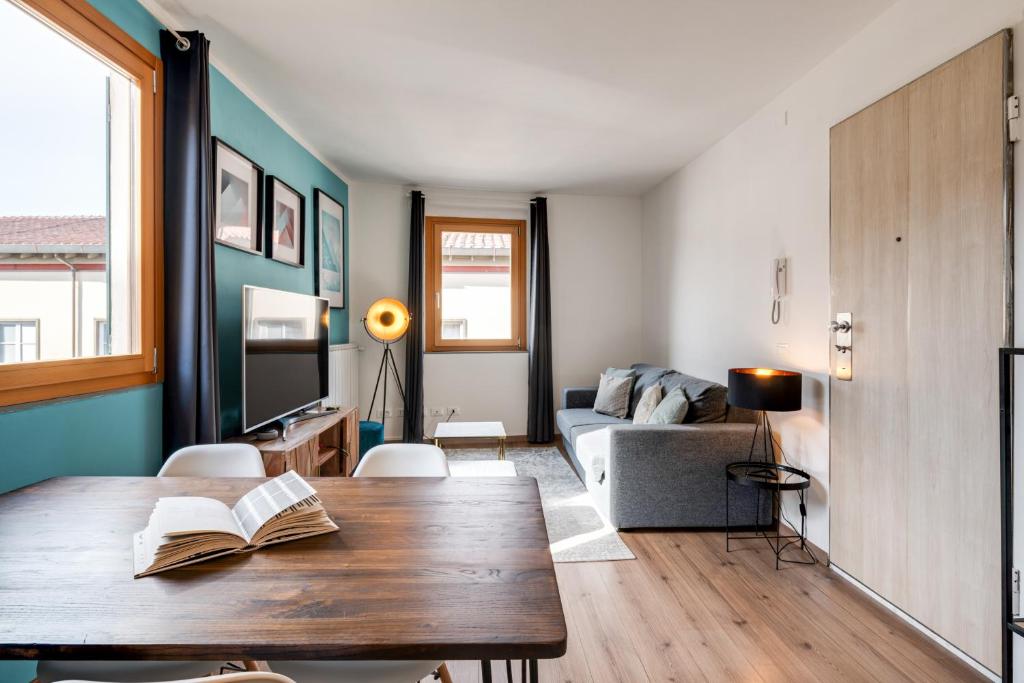 un soggiorno con tavolo e divano di Santa Croce Flat - Modern Apartment a Firenze