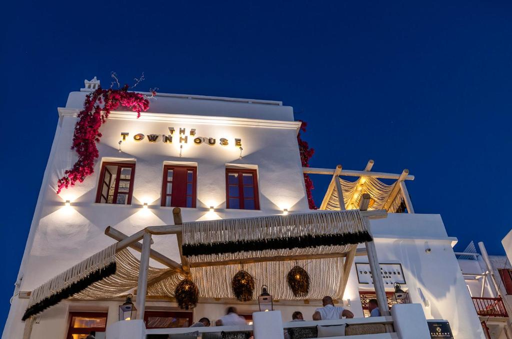 a white building with a sign on the side of it at The TownHouse Mykonos in Mýkonos City