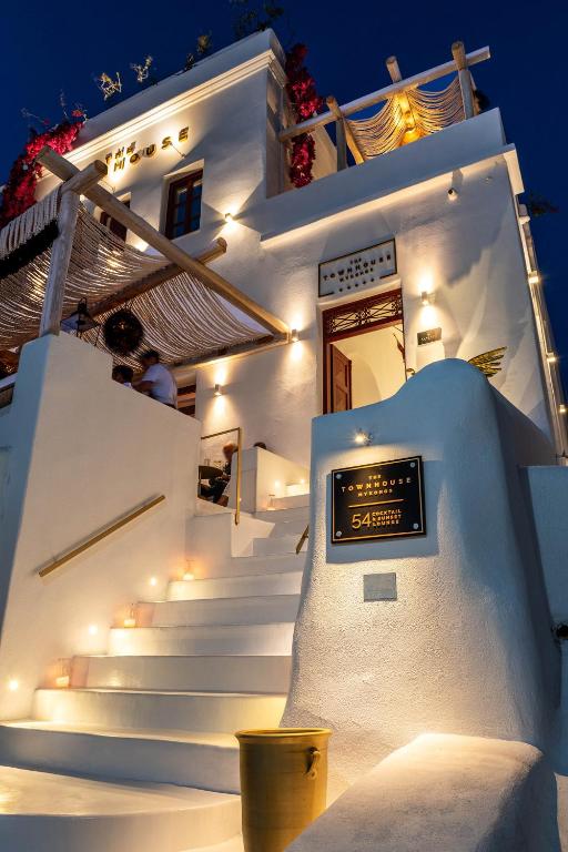 a white building with stairs and a sign on it at The TownHouse Mykonos in Mýkonos City
