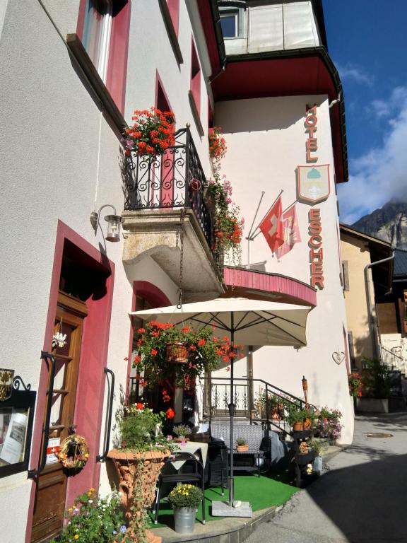 ein Gebäude mit einem Balkon mit Blumen darauf in der Unterkunft Hotel Escher in Leukerbad