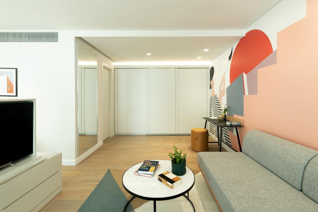a living room with a couch and a tv at Elma Hotel and Art Complex in Zikhron Ya'akov