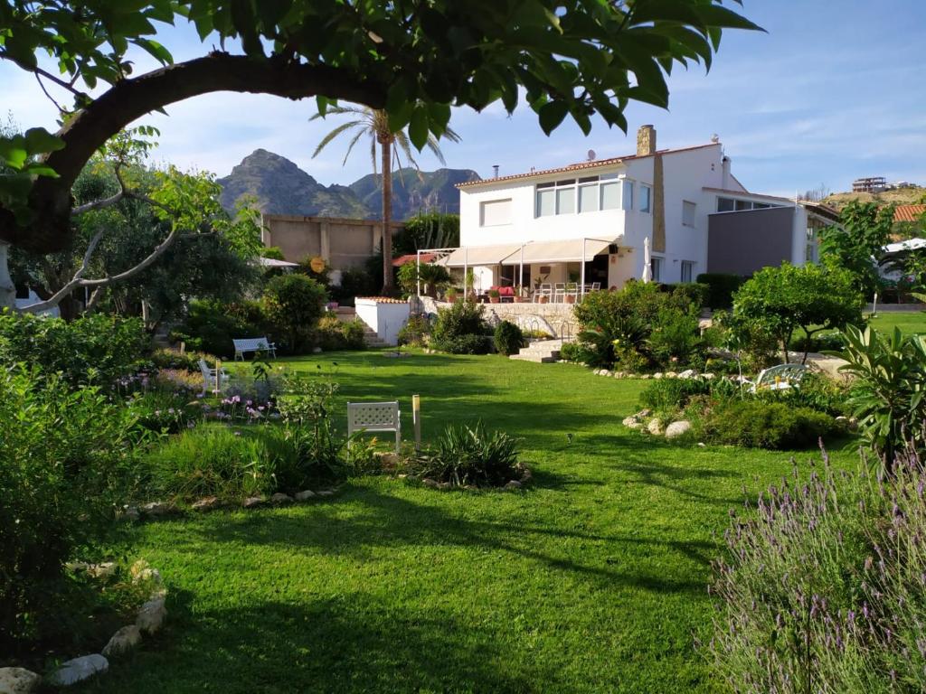 a garden with a house and mountains in the background at Berg & Zon in Gandía