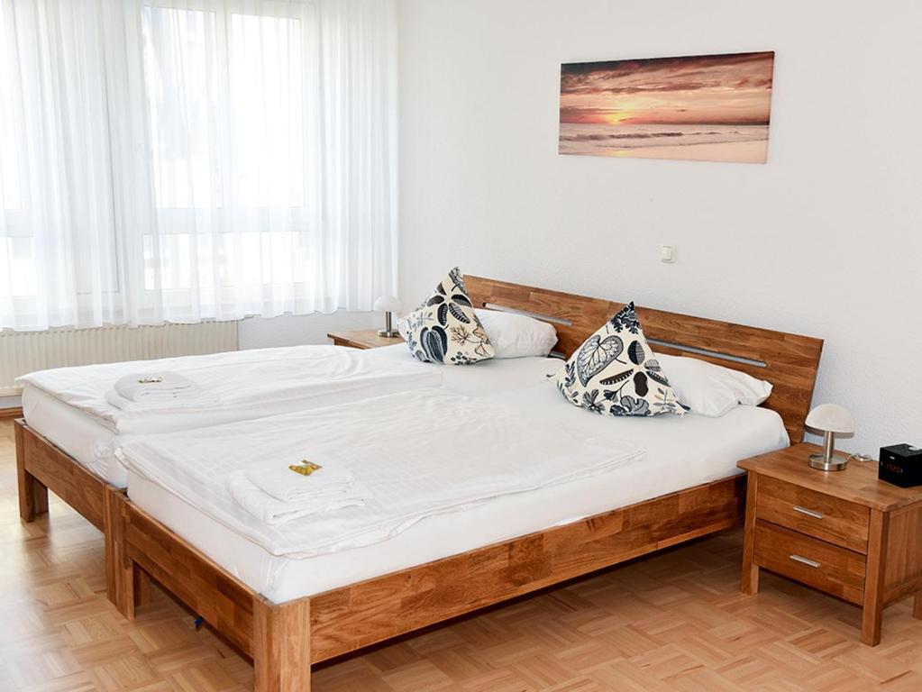 ein Schlafzimmer mit einem großen Holzbett mit Kissen darauf in der Unterkunft Residenz Hotel am Zuckerberg in Trier