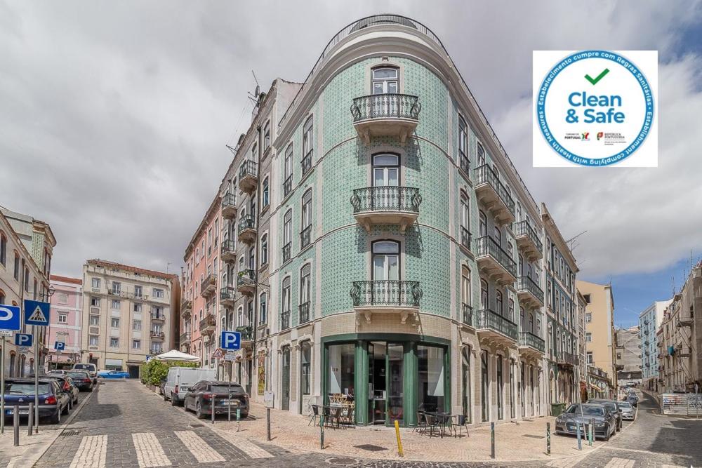 Be Lisbon Hostel Intendente في لشبونة: مبنى أخضر وبيضاء على شارع المدينة