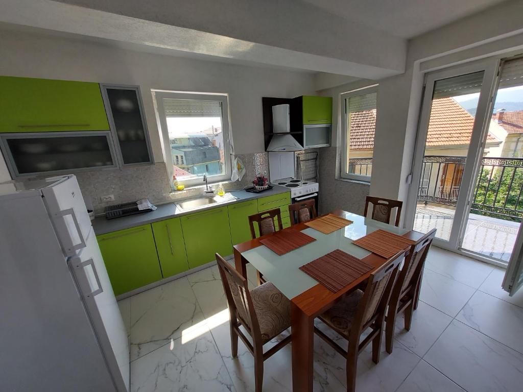 une cuisine avec une table et quelques armoires vertes dans l'établissement XXL APARTAMENT CITY CENTAR 1, à Bitola