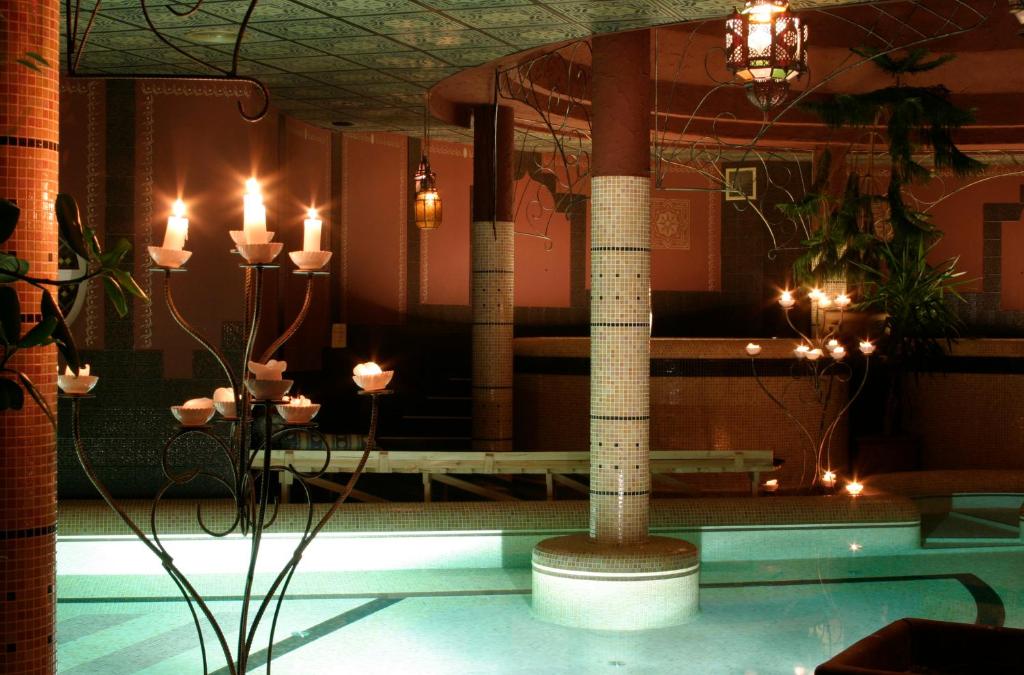 Cette chambre dispose d'une piscine avec bougies et pilier. dans l'établissement Puchner Kastélyszálló, à Bikal