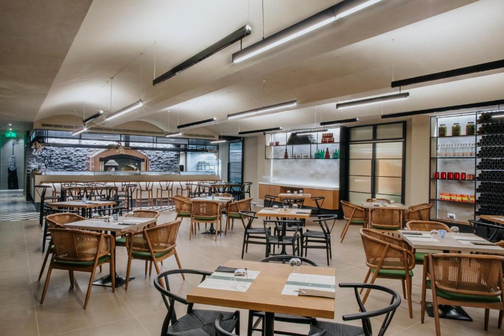 a restaurant with tables and chairs and a bar at Napa Plaza Hotel (Adults Only) in Ayia Napa