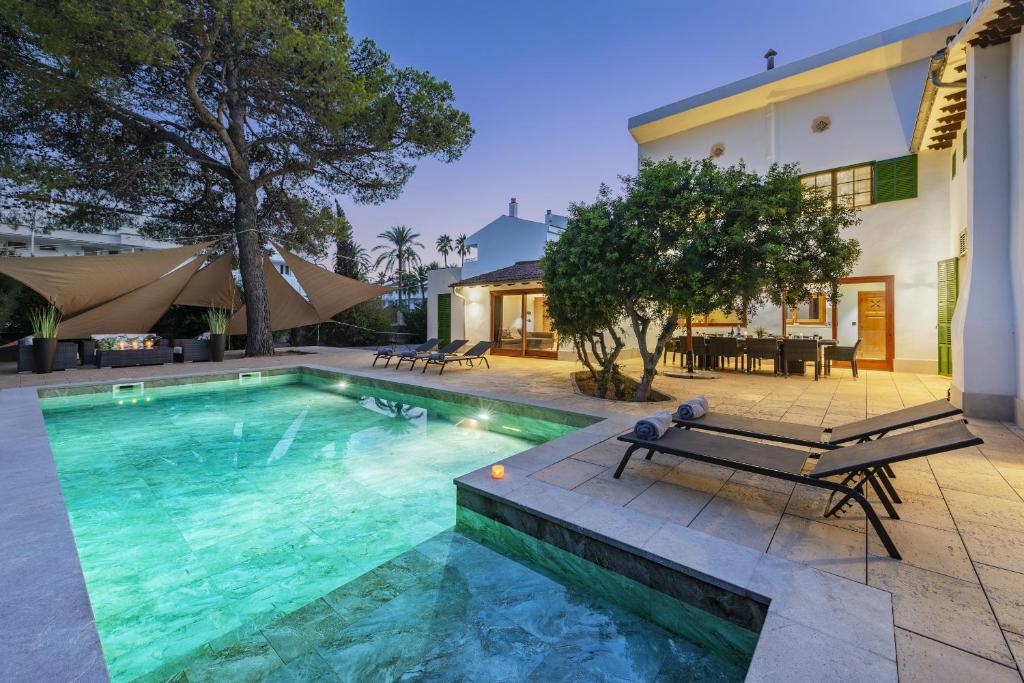 a swimming pool in front of a house at Stunning Villa C'an Payeras in Port de Pollensa