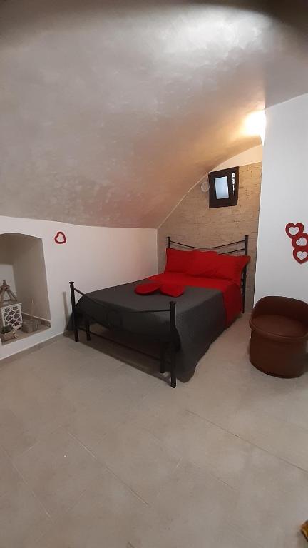 1 dormitorio con 1 cama con almohadas rojas en La casetta nel claustro 2, en Altamura