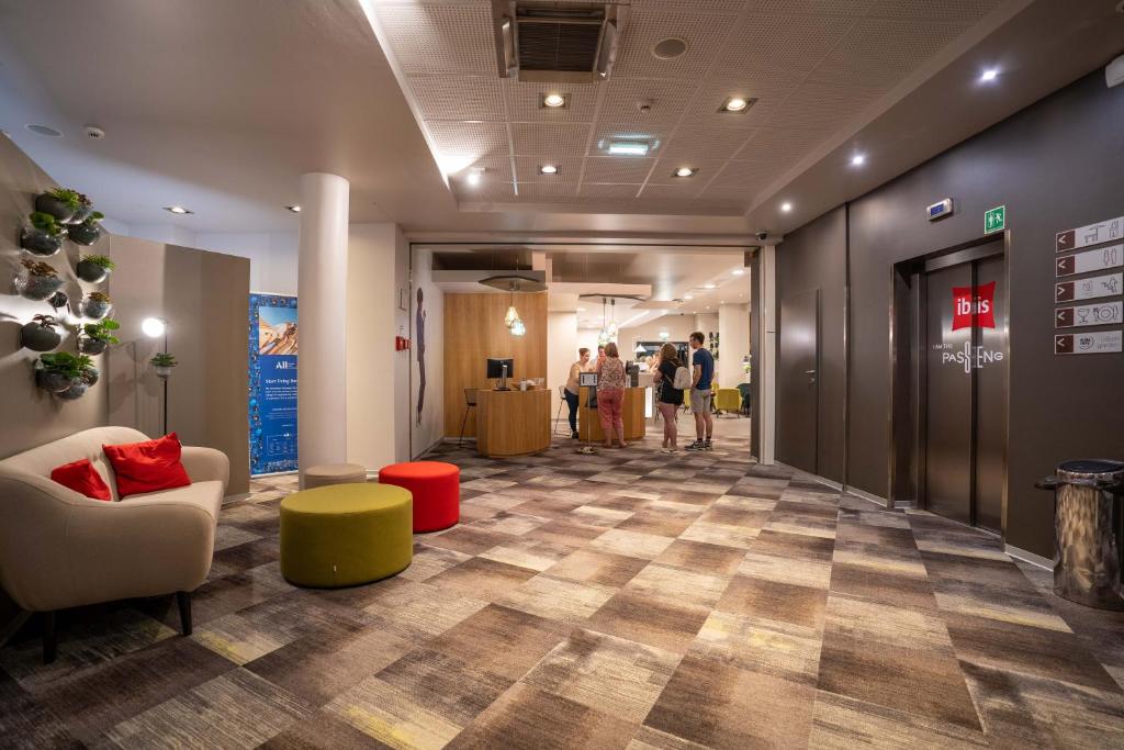 um corredor com um hall de entrada com pessoas ao fundo em Ibis Hotel Plzeň em Plzeň
