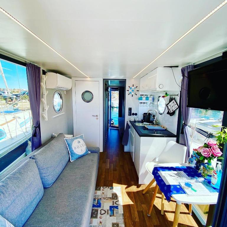 a living room with a couch and a kitchen in a rv at Houseboat Seabreeze in Alghero