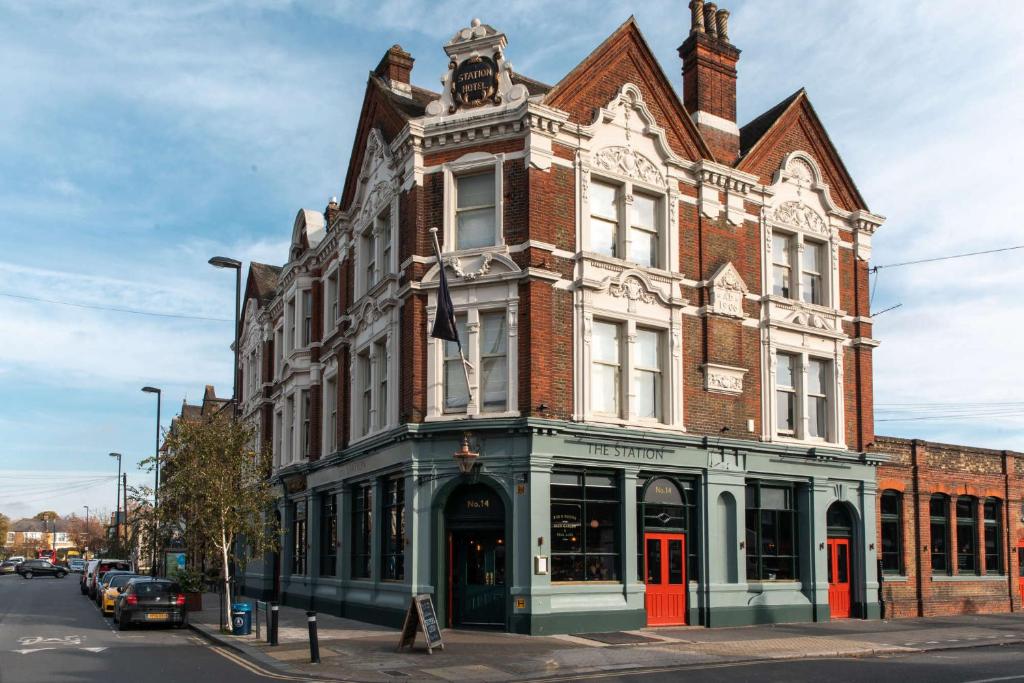 un gran edificio de ladrillo en la esquina de una calle en The Station Hotel, en Londres