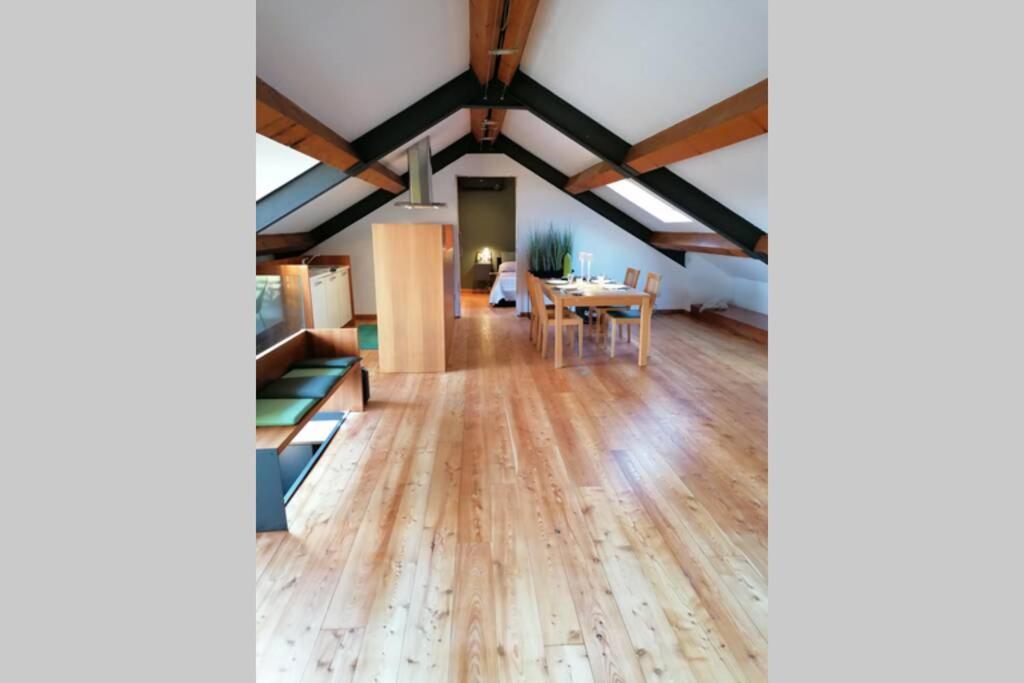 a room with a wooden floor and a dining room at Arona 01 attic mansarda secondo piano no ascensore in Arona