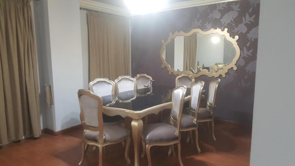 - une salle à manger avec une table, des chaises et un miroir dans l'établissement HOLIDAY VILLA 1, au Caire