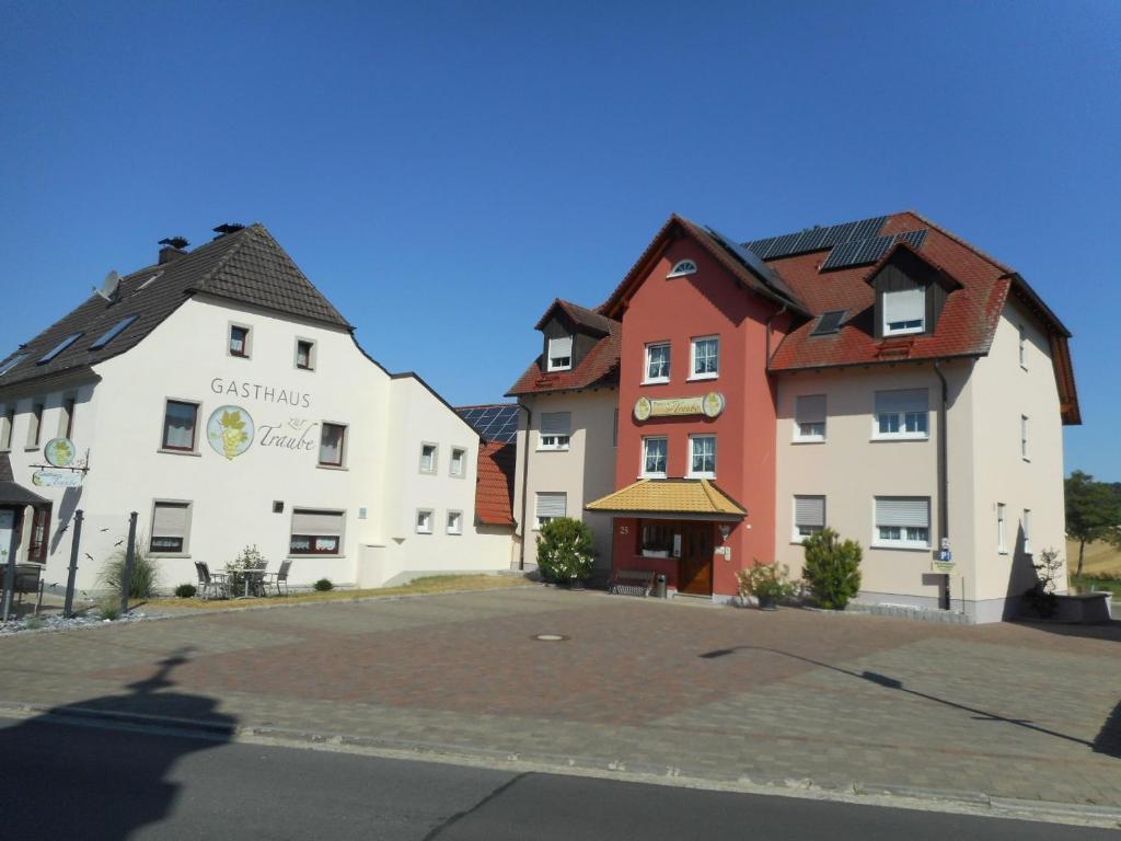 un groupe de bâtiments assis à côté d'une rue dans l'établissement Pension zur Traube 3 Sterne, à Oberschwarzach