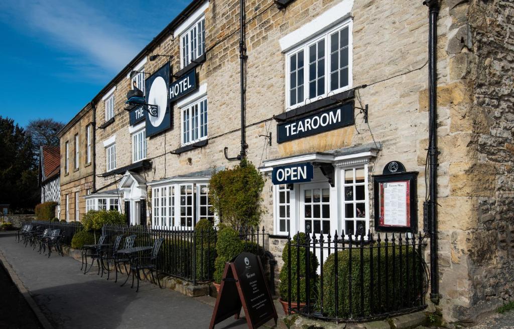 um velho edifício de tijolos com uma placa para um restaurante em The Black Swan - The Inn Collection Group em Helmsley