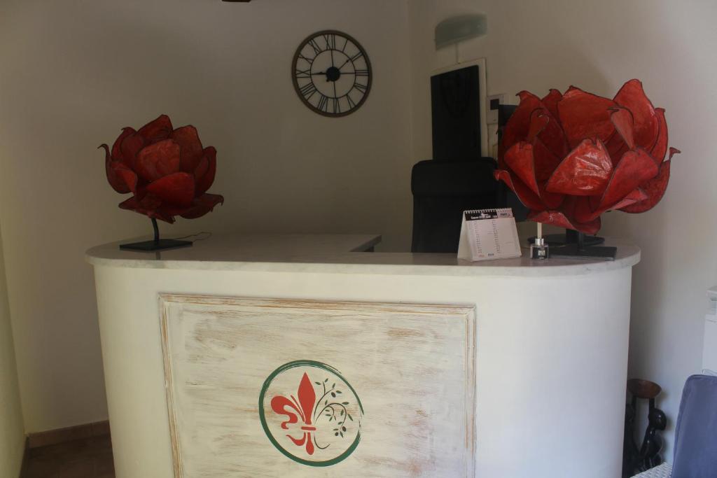 Un mostrador con dos flores rojas encima. en SOCIETA' AGRICOLA LAMBURE SRL en Popiglio
