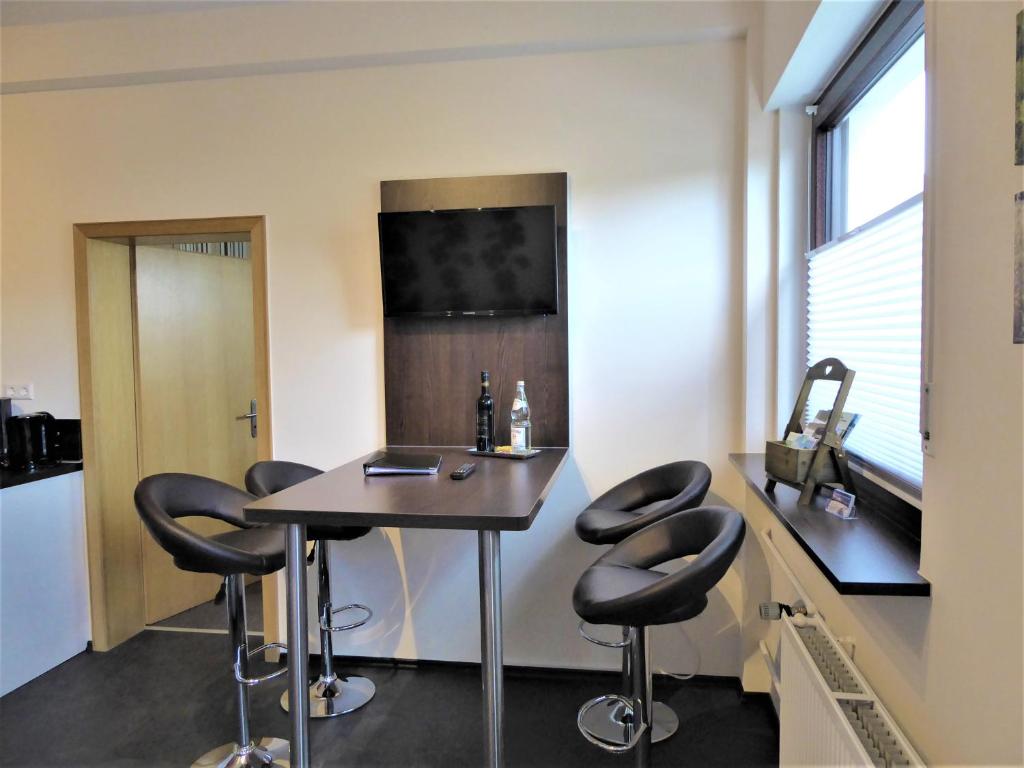 Una cocina con una mesa y taburetes en una habitación. en Cityview Winterberg Ferienwohnung in der City, en Winterberg