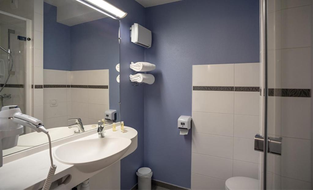 a bathroom with a sink and a toilet and a mirror at Ace Hôtel Salon de Provence in Salon-de-Provence