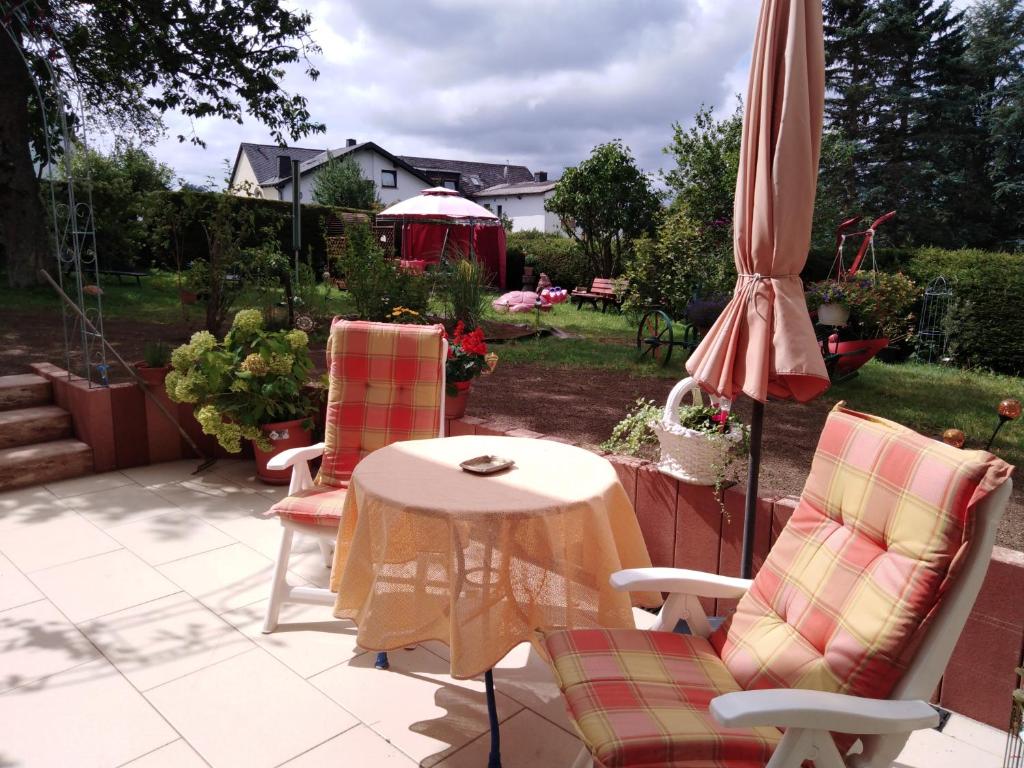 a patio with a table and an umbrella and chairs at FeWo Sonnenblume in Daun