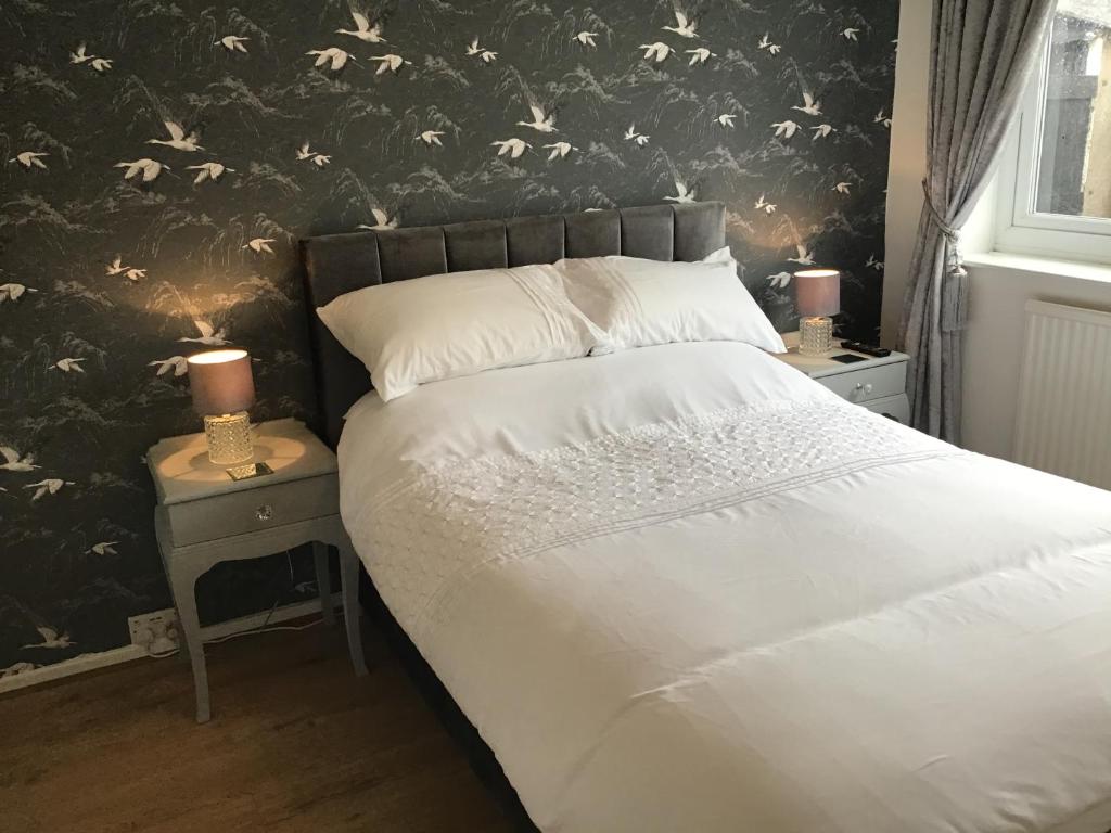 a bedroom with a bed and two night stands with two lamps at Beverley Ffrith beach Prestatyn in Prestatyn