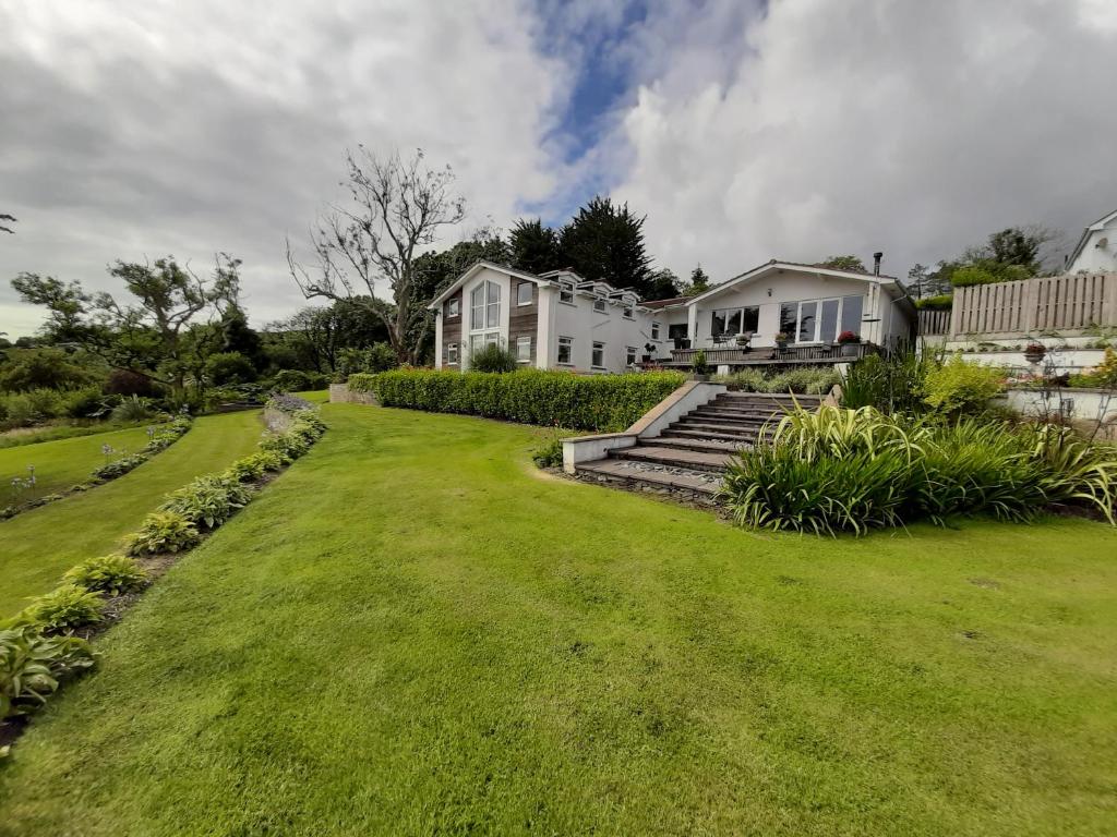 a large yard with a house and a grassy field at At Cedar Lodge Apartment in Ramsey