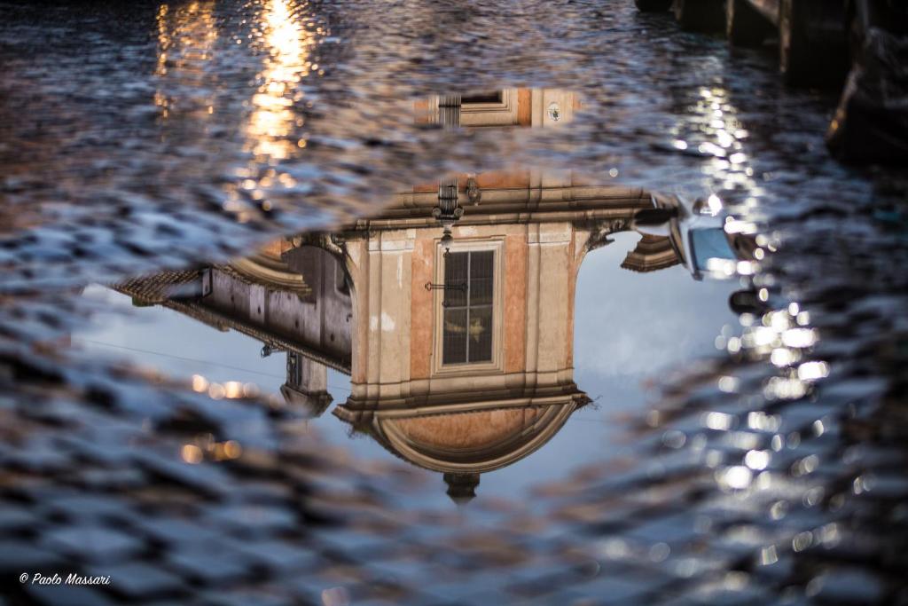 a reflection of a building in a puddle of water at Tiberim Apartment Trastevere 9 in Rome