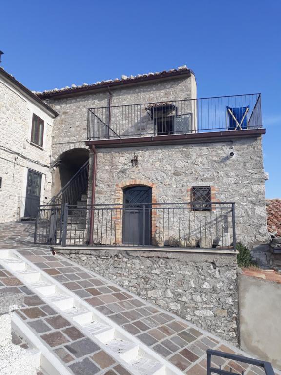 un edificio in pietra con balcone sopra di Casetta nel borgo a Torrebruna