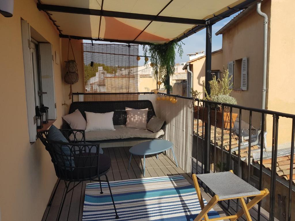patio con sofá y mesa en el balcón en Beau duplex avec terrasse - Centre historique, en Aix-en-Provence