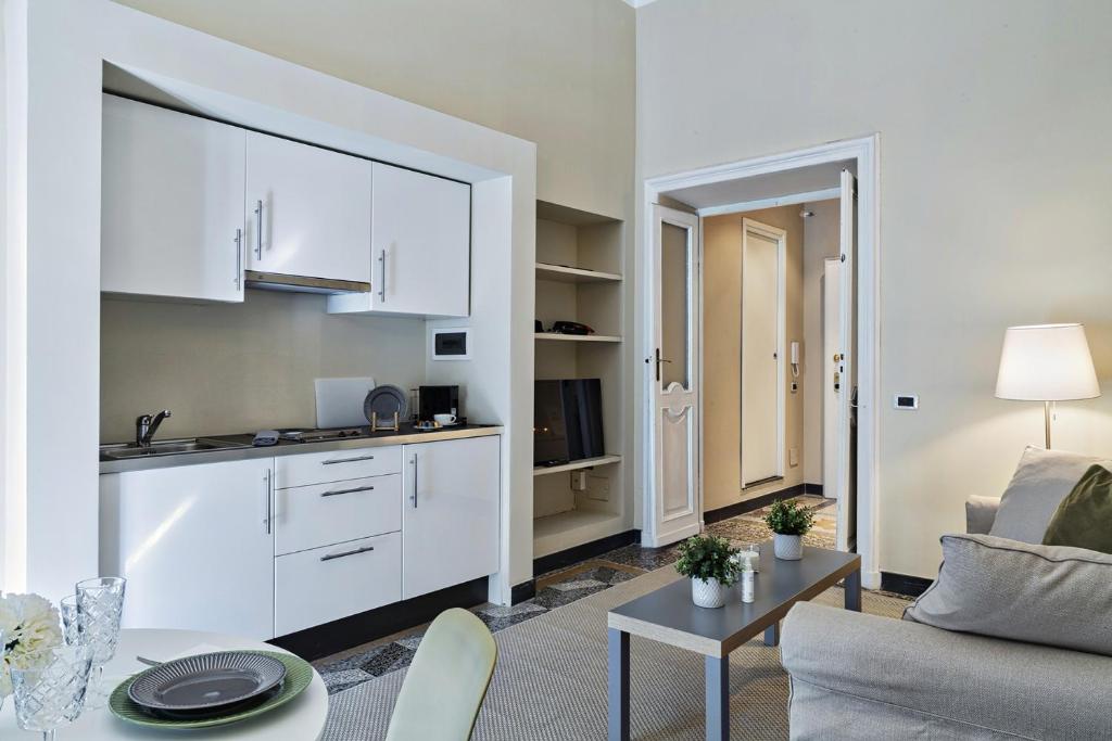 Una sala de estar con un sofá y una cocina. en Via Roma Luxury Apartment by Wonderful Italy, en Génova