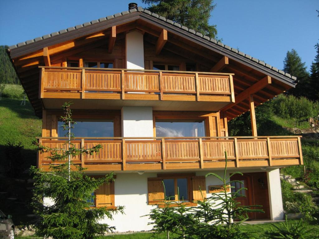 a wooden house with a balcony on a hill at Chalet Arc-en-Ciel in Nendaz