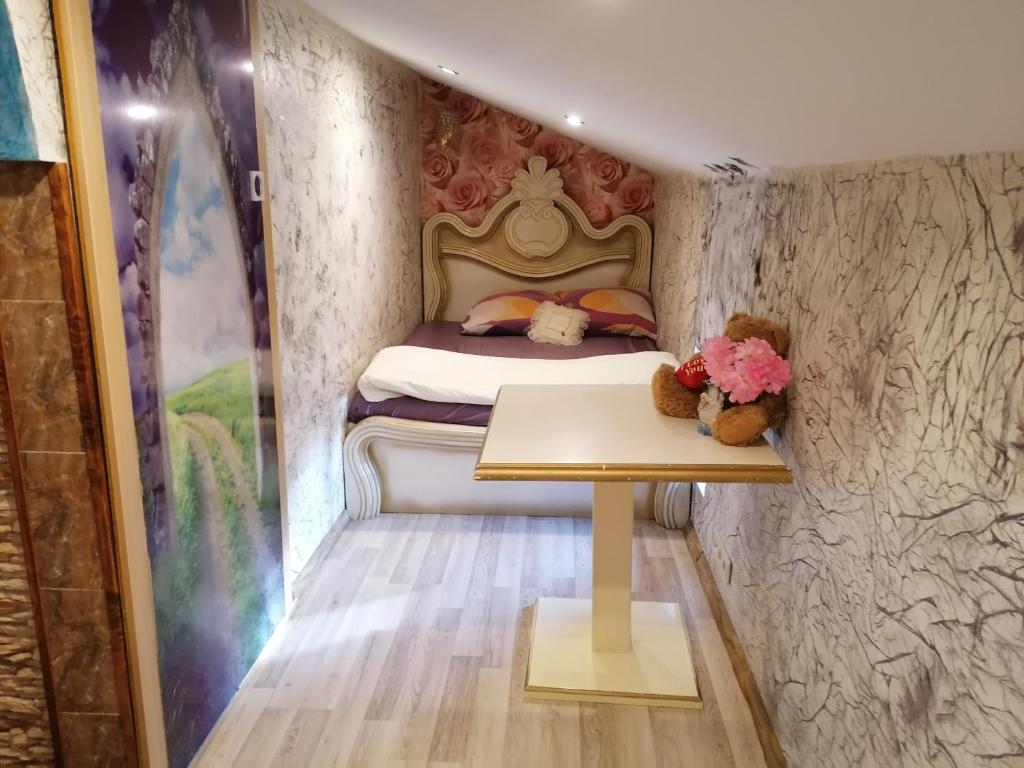 a bedroom with a bed with a table and teddy bears at Plata iela Ventspils center apartment in Ventspils